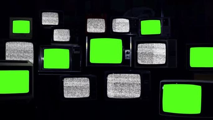 一堆老式电视打开静态电视，七台复古电视打开绿色屏幕。深色。放大。4k分辨率。