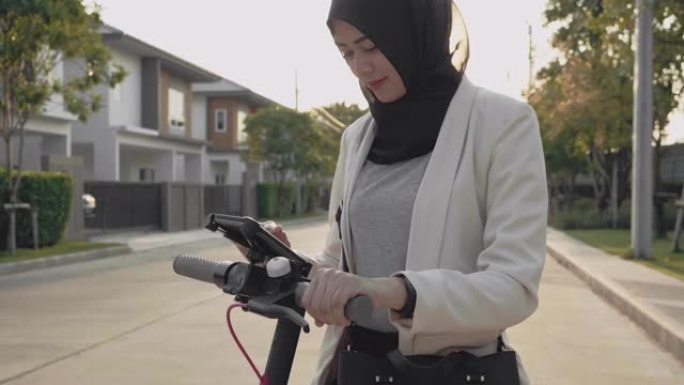 穆斯林妇女使用手机通过app解锁电动踏板车