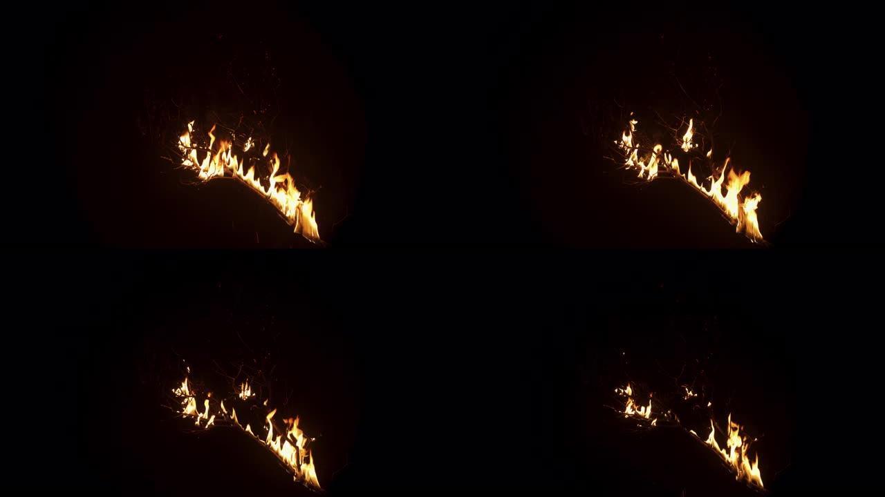 黑色背景上在火焰中燃烧的木树枝的慢动作镜头。火慢慢消失了。孤立的模型，用于特殊效果，VFX，后期制作