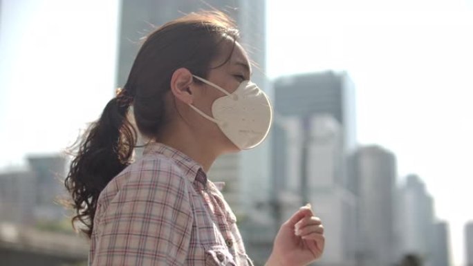 城市中戴着口罩的亚洲妇女，空气污染