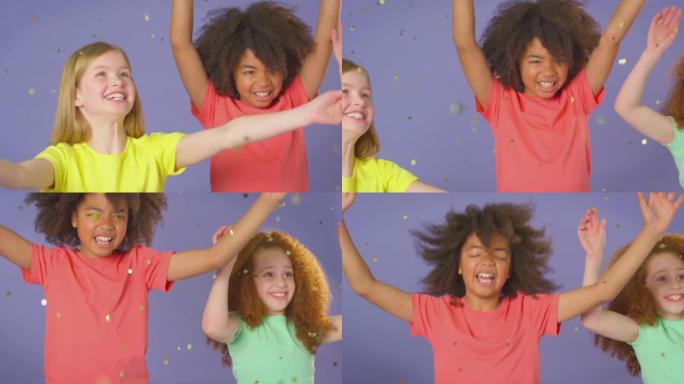 三个孩子朋友在紫色背景下闪闪发光的空中跳跃的工作室肖像镜头-慢动作拍摄