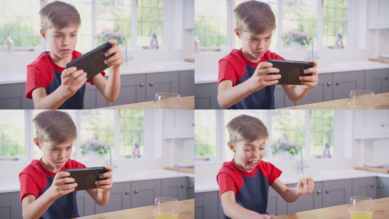 家里的男孩在厨房玩手机游戏