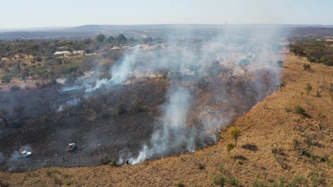 气候紧急情况。试图扑灭南部非洲因干旱和气候变化引起的草地大火的消防员的鸟瞰图