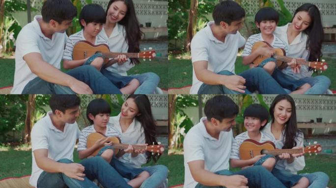 快乐的亚洲家庭弹吉他，在家一起在花园里玩得开心