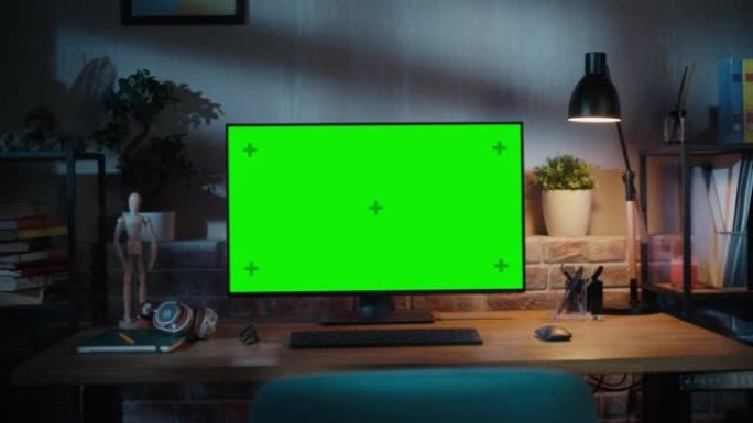 现代个人电脑显示器，绿屏模拟显示器站在桌子上，键盘、鼠标、笔、笔记本和耳机。阁楼客厅空间舒适的家庭办