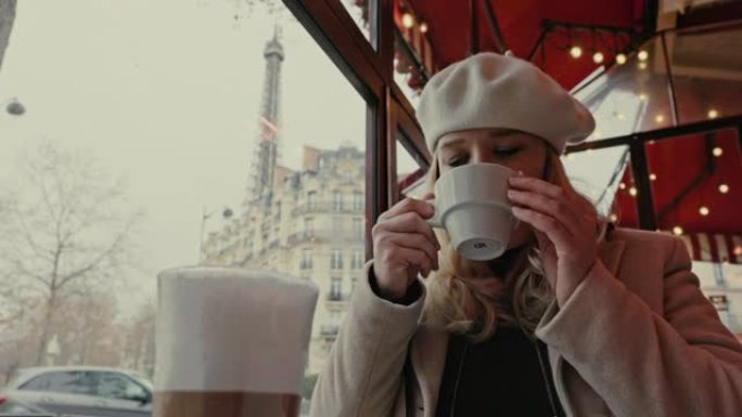 Mid成年女性女士在埃菲尔铁塔附近的一家咖啡馆里喝杯咖啡