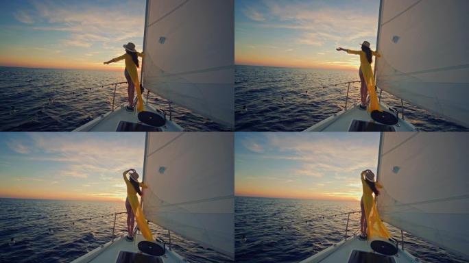 穿着黄色长裙的SLO MO女人享受日落时的风帆