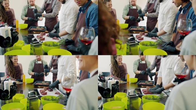 在烹饪课程期间，围裙中的快乐人群在厨房做饭
