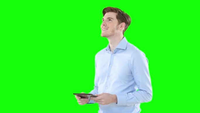 男人在绿屏背景下使用数字平板电脑