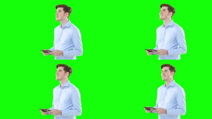 男人在绿屏背景下使用数字平板电脑