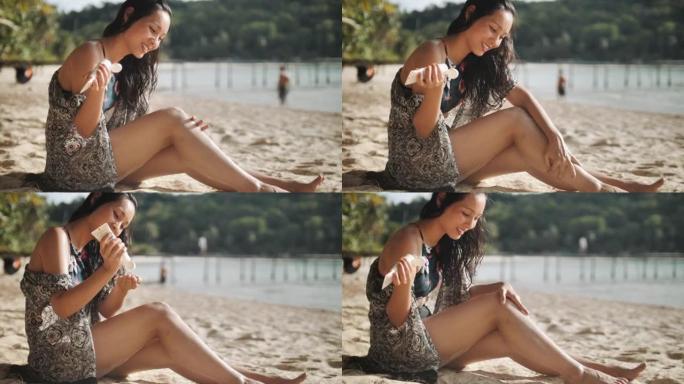 年轻女子正在海滩上涂抹防晒霜