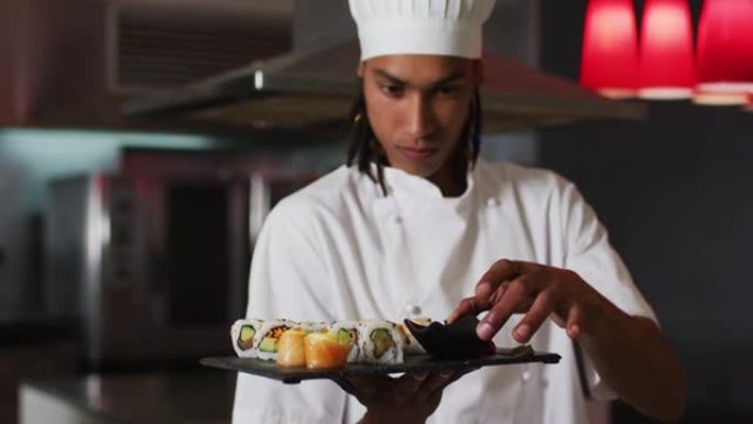 混血男厨师站在厨房里做一盘不错的寿司