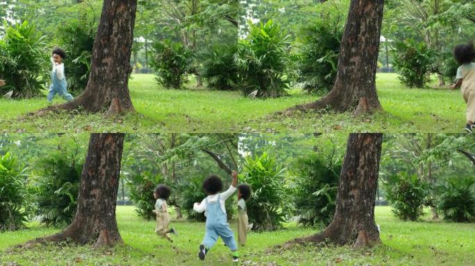 两个年龄在4-5岁的非洲民族儿童一起在公园跑步，同时花时间在户外野餐暑假。可持续生活方式，野餐概念。