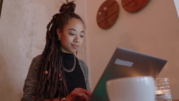 年轻女性自由职业者在wifi咖啡馆使用笔记本电脑