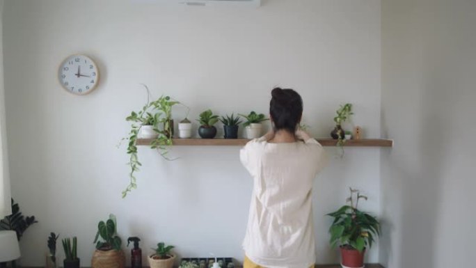 在家中的爱好: 时髦的女性在她的房间里装饰和护理植物