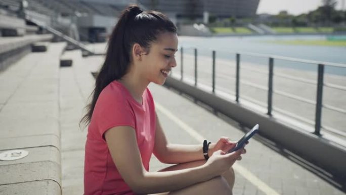 一名女性在田径跑道上使用电话的4k录像