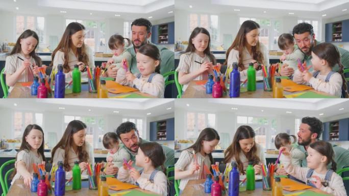 唐氏综合症女儿的家庭坐在家里的桌子旁一起做手工制作卡片