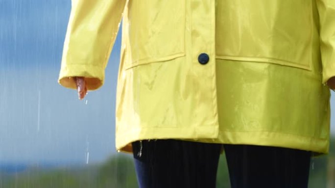 穿着雨衣站在雨中的SLO MO女人