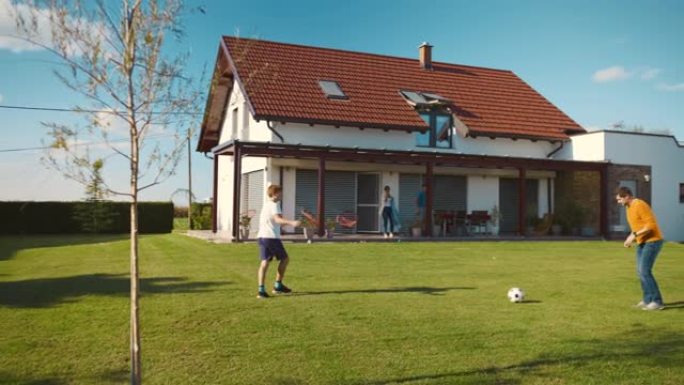 SLO MO父子在独立屋的草坪上踢足球