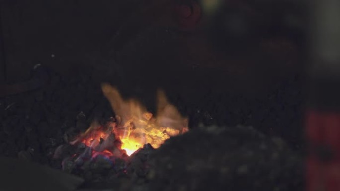 铁匠锻造中的火焰和炽热的煤的特写