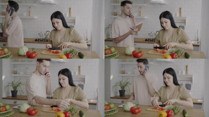 年轻女子正在准备沙拉，而丈夫在手机上讲话并在家里的厨房里吃蔬菜