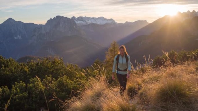 健康的女人保持健康的生活方式，日落时在山上徒步旅行