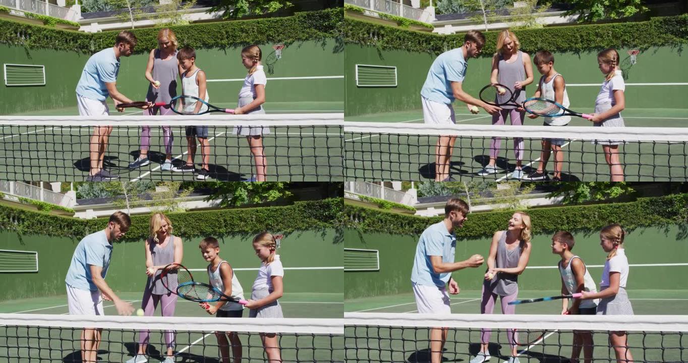 在阳光明媚的日子里，高加索人的父母教他们的孩子在网球场打网球