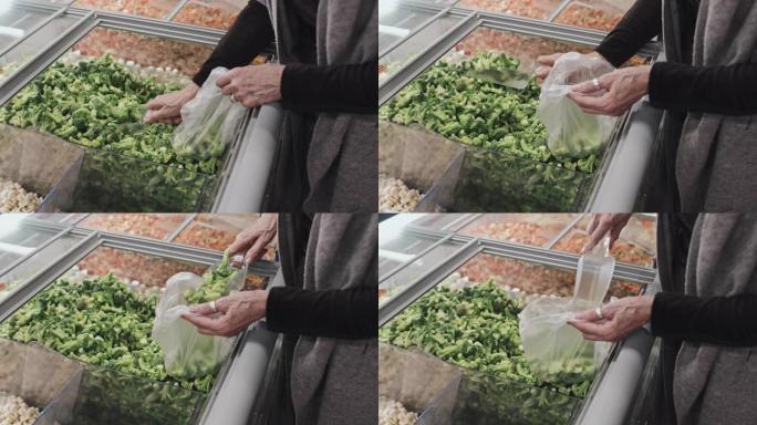 女人在超市里捡冷冻西兰花