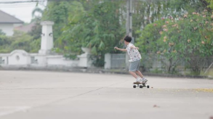玩滑板的亚洲男孩小孩玩耍开心