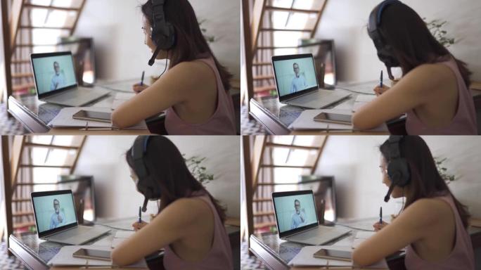 特写sideview亚洲中国美女在家用笔记本电脑和耳机在线与讲师讨论