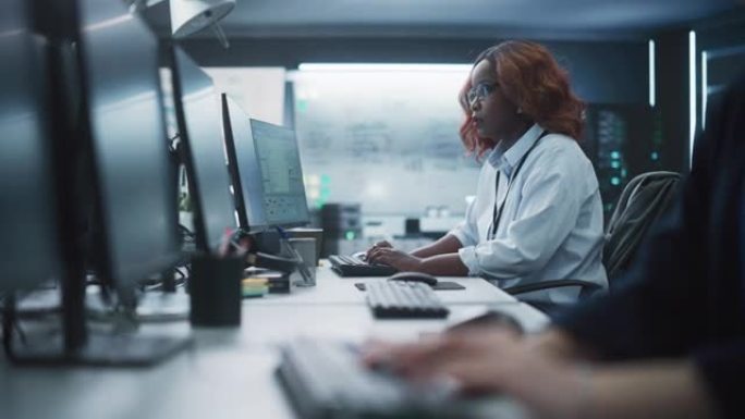 在技术办公环境中，一位体贴的黑人女工程师在计算机上工作的肖像。研发部门为一个创新的互联网项目编写软件
