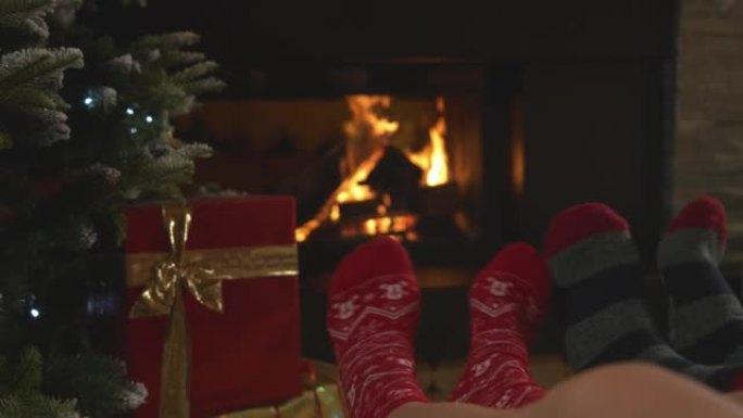 特写情侣，脚上穿着圣诞袜，在壁炉旁放松