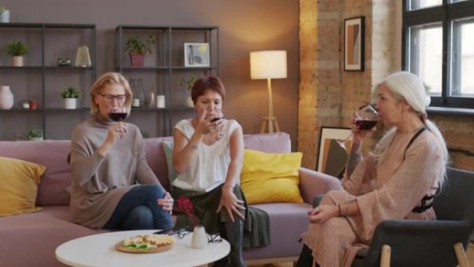 三个高级女友在家庭聚会上碰杯红酒