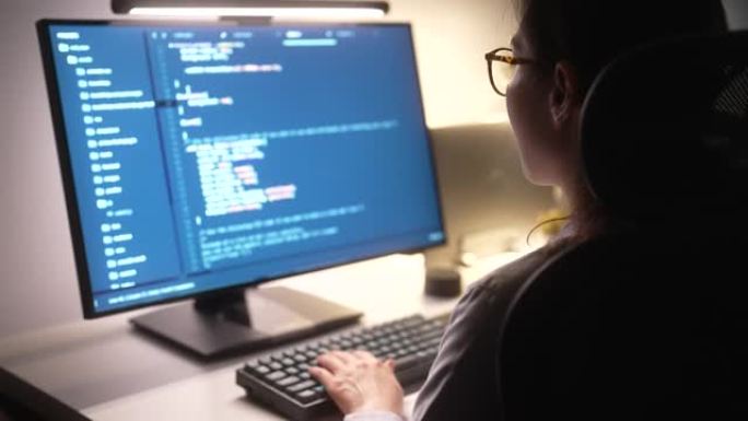 女程序员晚上在办公室的办公桌上写开发代码