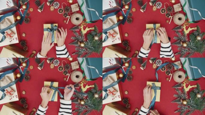 女孩手的俯视图打开礼物礼品盒红色背景的冬季圣诞装饰品。