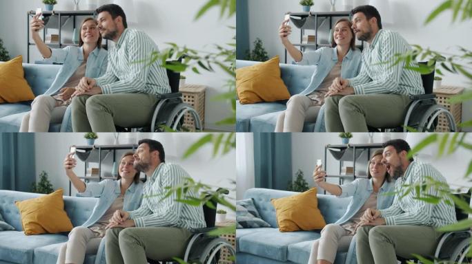 坐在轮椅上的快乐夫妇和在家用智能手机相机自拍的女人