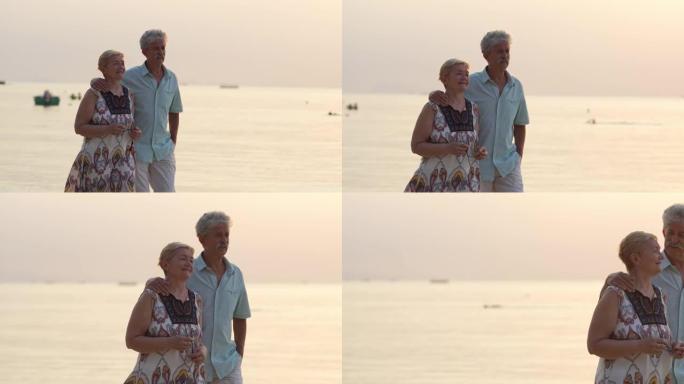 高级夫妇悠闲地在海滩散步
