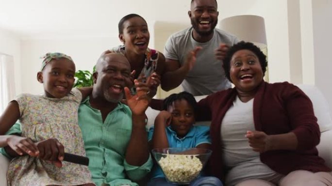 三代非洲裔美国家庭在家里看电视时一起欢呼