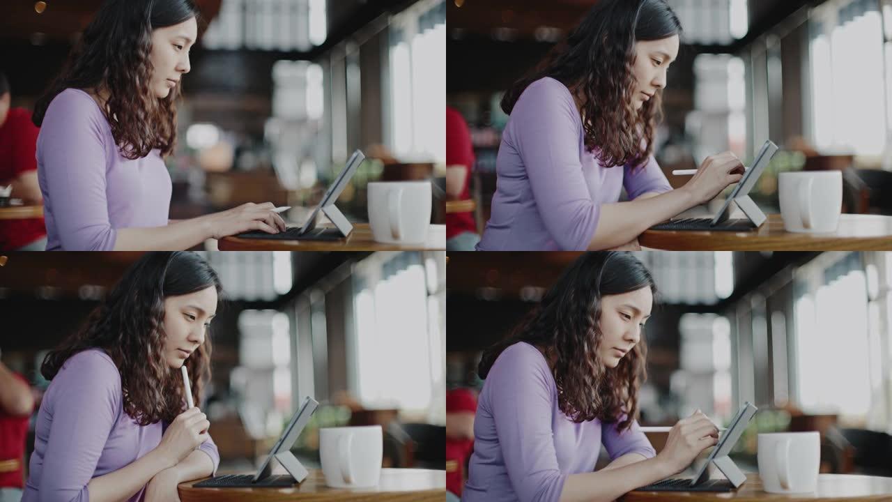 年轻的女商人在咖啡店使用数字平板电脑