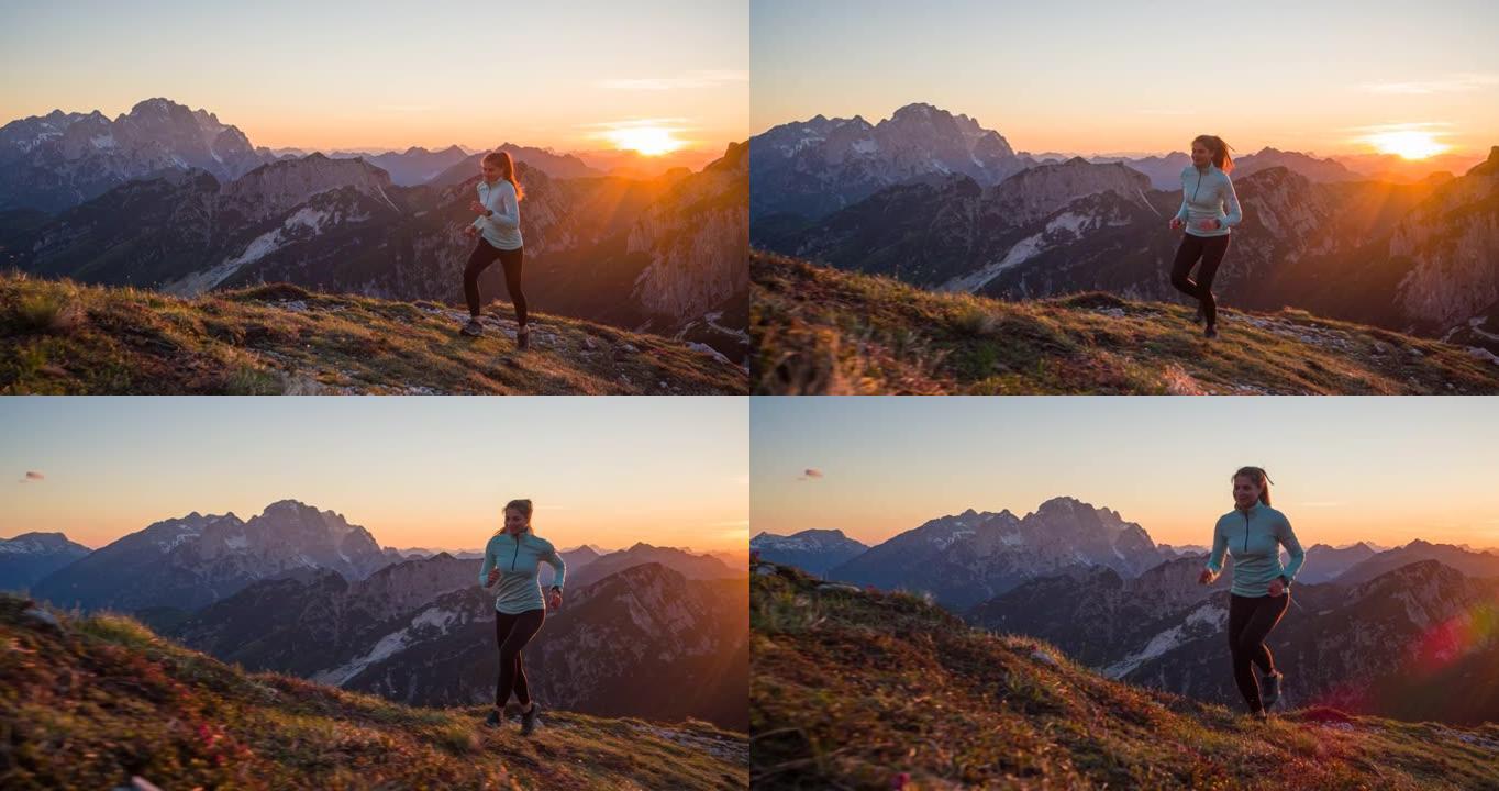 健康的女运动员保持健康的生活方式，在岩石小径和草坡上的山上奔跑，日落时的壮丽景色