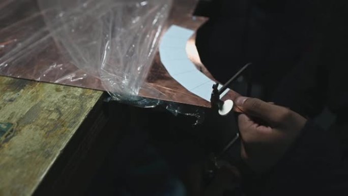 亚洲男学生在大学工作台上使用手锯的高角度视图