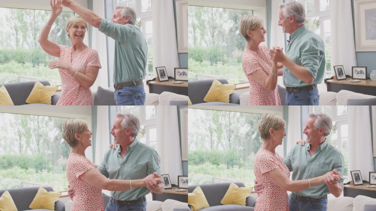 浪漫的高级退休夫妇一起在家里的休息室跳舞