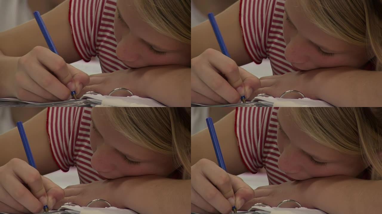 阿根廷科伦特斯，女学生用蓝笔用环形活页夹书写考试。特写。