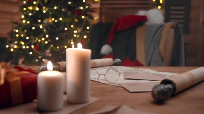 带有蜡烛的圣诞老人餐桌的视图圣诞老人的眼镜和带有儿童名字的卷轴