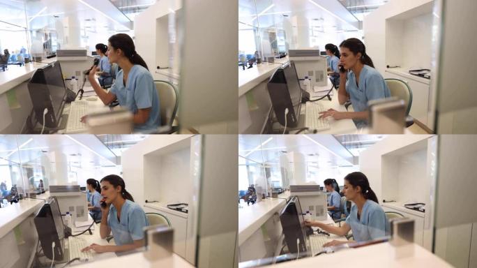 专注的女护士在医院接待处工作，用电脑接听电话