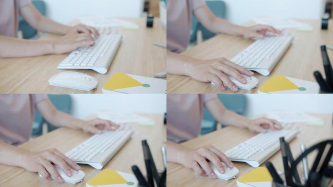 现代办公室室内使用键盘和pc鼠标的女人的手的特写