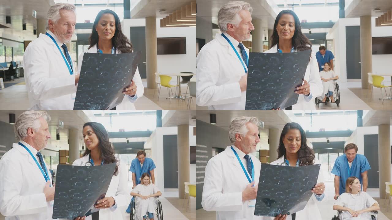 穿着白大褂的医生在繁忙的医院与女同事讨论患者扫描