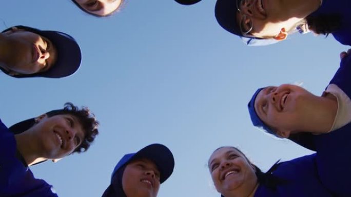 成群的女棒球运动员在蓝天下的低角度视图