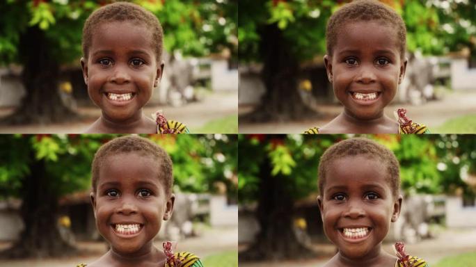 一个害羞的真实的非洲小女孩在镜头前微笑，背景是模糊的绿色植物。黑人女孩子代表未来、希望和接纳。纪录片