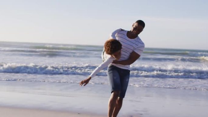 非裔美国父亲接儿子在海滩玩耍